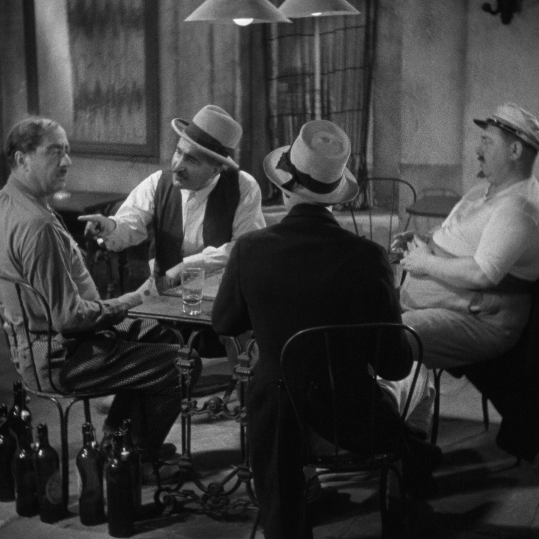 Quatre hommes autour d'une table en noir et blanc